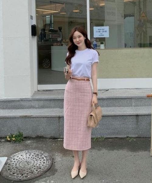 ผู้หญิงเอเชียใส่เสื้อยืดสีขาวและกระโปรงยาวทรงเอ